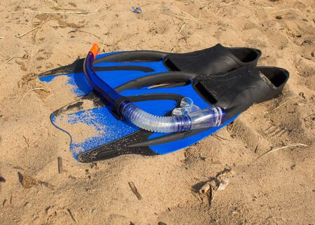swimming snorkel and fins lying on the sandの写真素材