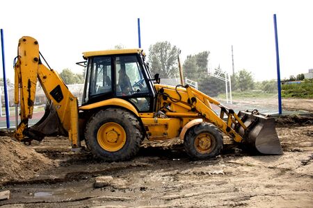 yellow excavator stands on the construction siteの写真素材