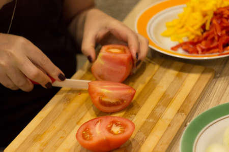 the process of cooking pizza, sliced tomatoの写真素材