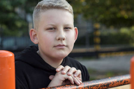 the young man in theme jacket with blond hair standing on the Playgroundの写真素材
