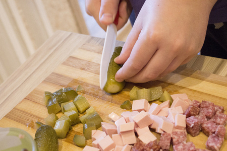 the boy cut the ingredients for the pizzaの写真素材
