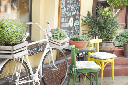 background, an old white Bicycle stands near the cafeのeditorial素材
