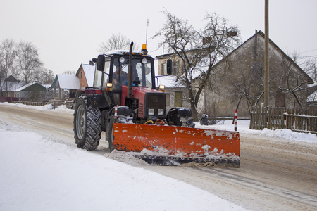 red tractor clears the road from snowの写真素材