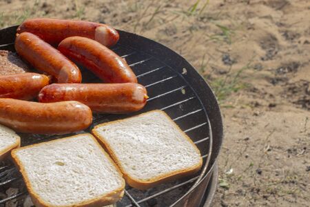 white bread and sausages are fried on the grillの写真素材