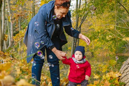 autumn.a mother and her child walking in autumn Park and smilingの写真素材