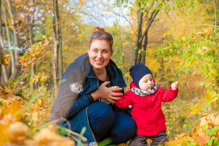 autumn.a mother and her child walking in autumn Park and smilingの写真素材