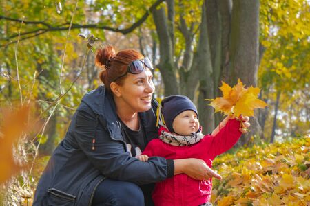 autumn.a mother and her child walking in autumn Park and smilingの写真素材