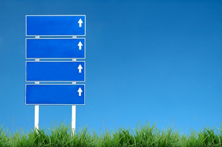 roadsign with green grass and blue skyの写真素材