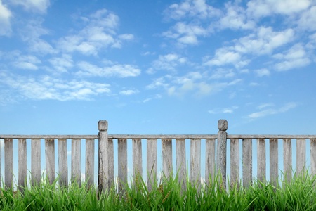 wooden fence with green grass and blue skyの写真素材