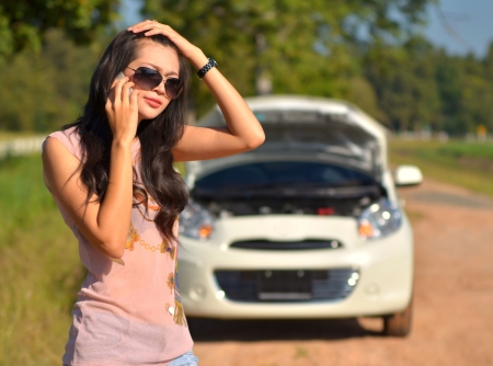 A woman calls for assistance  after her car broke down の写真素材