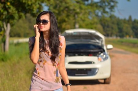 A woman calls for assistance  after her car broke down の写真素材