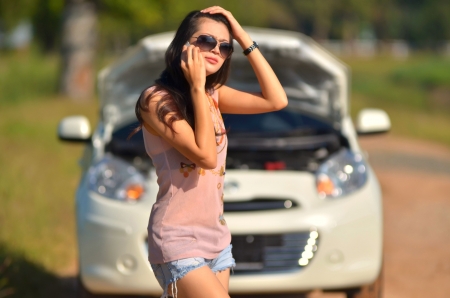 A woman calls for assistance  after her car broke down の写真素材