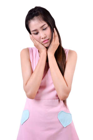 Sad beautiful woman standing against a white backgroundの写真素材