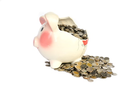 Pink piggy bank broken with money isolated on white backgroundの写真素材