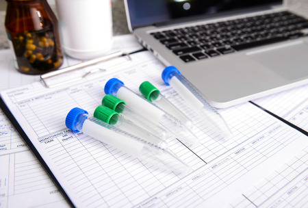 sample tube with labtop  and other medical object on the tableの写真素材