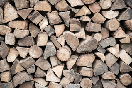 Cut and split firewood stacked in heap