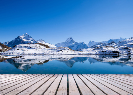 snow peaks of Jungfrau region grindelwald switzerland with wooden terraceの写真素材