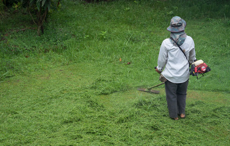 man cutting grass with a lawn mowerの写真素材