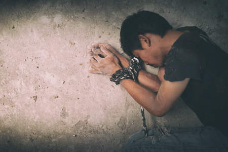 hopeless man hands tied together with rope, human traffickingの写真素材