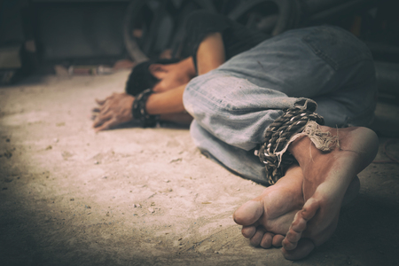 hopeless man hands tied together with rope, human traffickingの写真素材
