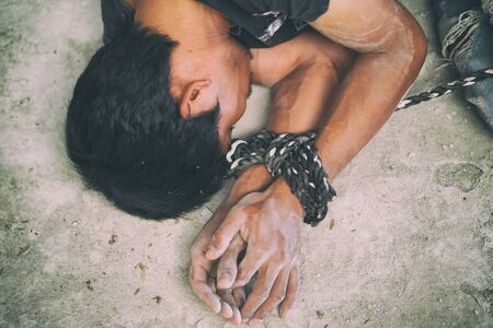 hopeless man hands tied together with rope, human traffickingの写真素材