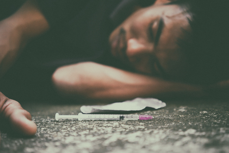 drug addict man with syringe in actionの写真素材