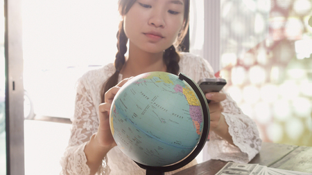 Women explore the globe to plan their travelの写真素材