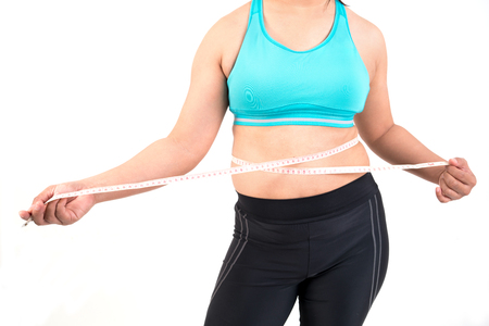 chubby  woman measuring her waistline fat tummyの写真素材