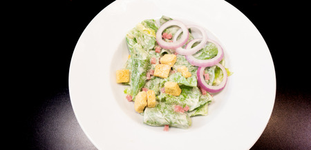 Fresh healthy Caesar salad on white dishの写真素材