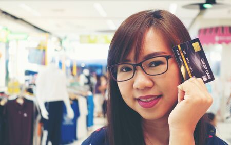 Women holding credit cards and shopping cart, shopping conceptの写真素材