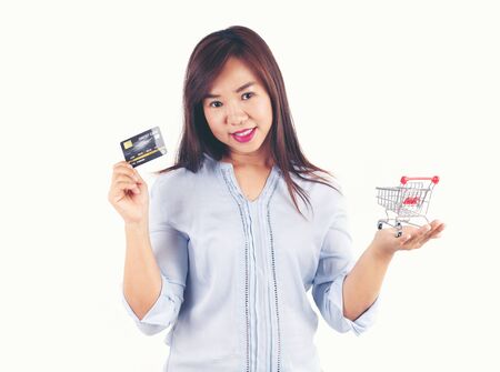 Women holding credit cards and shopping cart, shopping conceptの写真素材