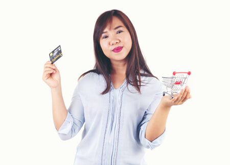 Women holding credit cards and shopping cart, shopping conceptの写真素材