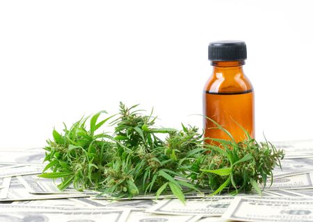 cannabis with cannabidiol (cbd) extract on hundred dollar banknoteの写真素材