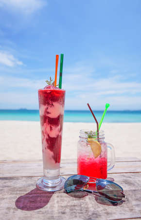 fresh cold drink on wooden table and  Summer blurred background of beachの写真素材