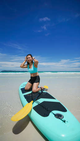 woman on sup board or paddle board at the beachの写真素材
