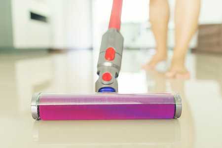 woman clean floor with a vacuum cleaner at homeの写真素材