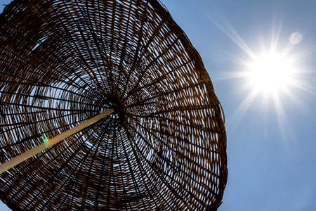 straw beach umbrella against the skyの写真素材