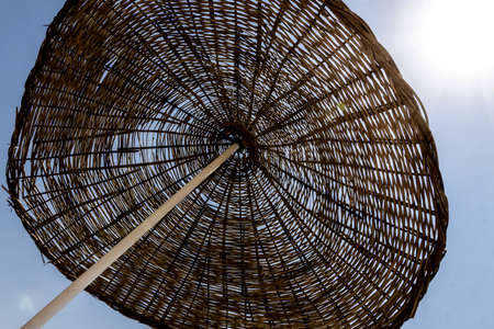 close up straw beach umbrella against sunshineの写真素材