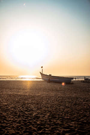 boat on a sand beach at sunsetの写真素材