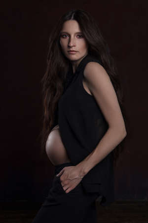 stylish portrait of pregnant woman on dark backgroundの写真素材