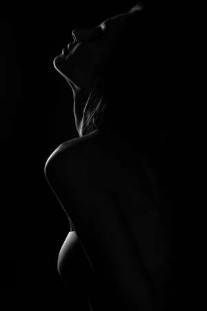 Black and white profile portrait of female in back light art photographyの写真素材