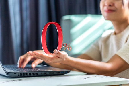 Woman using a laptop with a percentage sign in the screen, business conceptの写真素材