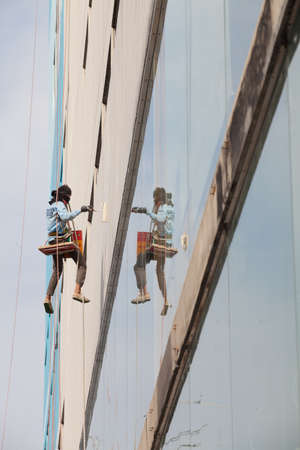 Painter on a rope. To paint the building.の写真素材