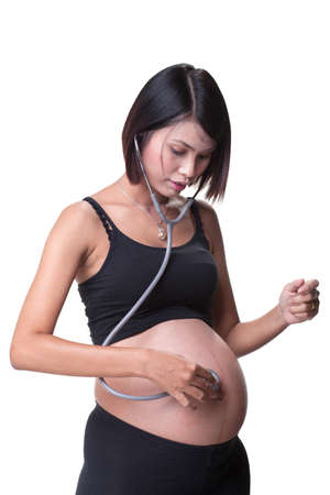 Asian pregnant women at 37 weeks gestational age used stethoscope to listening her baby heartbeatの写真素材