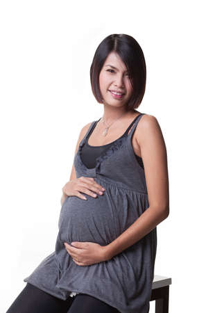 Pregnant women at 37 weeks gestational age sit on a chair relaxingの写真素材