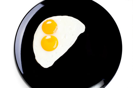 top view of fried egg on black dish