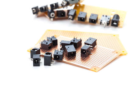 dc power jack and audio jack female placed on the pcb. Electronic printed board. Soldering iron is backgroundの写真素材