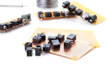 dc power jack and audio jack female placed on the pcb. Electronic printed board. Soldering iron is backgroundの写真素材