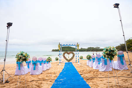 Beach wedding decorations . Interior colors blue sea . Blue drape Chair Cover , white and blue silk tie and a beautiful flower . Located on a quiet beach curves . A small beach in the south of Thailand.の写真素材