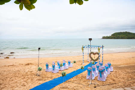 Beach wedding decorations . Interior colors blue sea . Blue drape Chair Cover , white and blue silk tie and a beautiful flower . Located on a quiet beach curves . A small beach in the south of Thailand.の写真素材